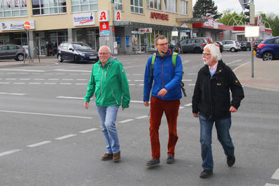 Die GRÜNEN Bezirksvertreter Fritz Goersmeyer, Benjamin Beckmann und Ulrich Riese überqueren die Ampel am Rodenberg Center.