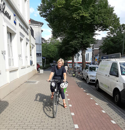Daniela Schneckenburger, die GRÜNE Oberbürgermeisterkandidatin, auf ihrem Fahrrad vor der Postkutsche.